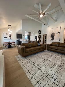 a living room with two brown leather couches and a rug at Midland Luxe, Pool, Fire Pit, Workspace, Pool Table in Midland