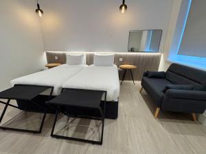 a bed in a room with a couch and a bed and a chair at RIOSHOUSE Henley in Henley on Thames