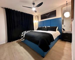 a bedroom with a blue bed and a ceiling fan at Midland Luxe, Pool, Fire Pit, Workspace, Pool Table in Midland +62 photos