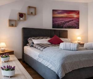 a bedroom with a large bed with purple flowers at Oaza Resnik in Zagreb
