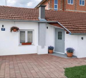 a white house with potted plants in front of it at Oaza Resnik in Zagreb