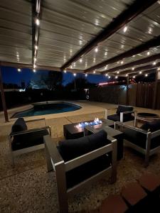 a patio with couches and a pool at night at Midland Luxe, Pool, Fire Pit, Workspace, Pool Table in Midland