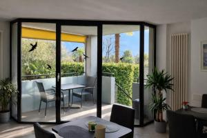 a balcony with a table and chairs and birds flying at Hotel Nessi Locarno in Locarno