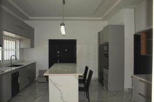 a large kitchen with a counter and chairs in it at MB Properties - situated behind Dalaba Estate about 500 meters from the famous OIC road in Madina Sey Kunda