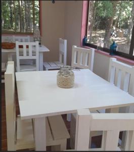 a white table and chairs with a jar on it at Cafeteria y cabañas Eluney - Koigue in Pucón
