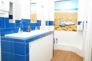 a blue and white bathroom with a beach mural at Amor Lisboa Hostel in Lisbon