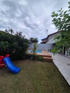 a yard with a playground with a blue slide at Elis Praia e Aconchego in Iguaba Grande