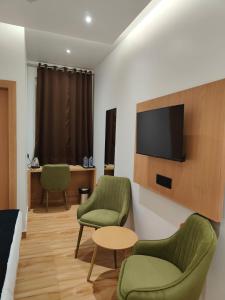 a room with two chairs and a flat screen tv at Hotel DG Residency in Guwahati