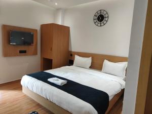 a bedroom with a bed with a tv on the wall at Hotel DG Residency in Guwahati