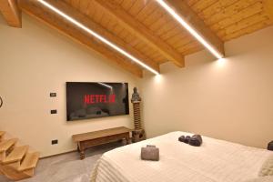 a bedroom with a tv on the wall at ArtiStone - "The Modern Loft" - Nature and Relax in Saint-Christophe