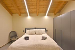 a bedroom with a large bed and a chair at ArtiStone - "The Modern Loft" - Nature and Relax in Saint-Christophe +19 photos