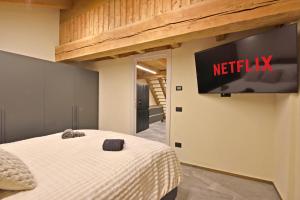 a bedroom with a bed with a television on the wall at ArtiStone - "The Modern Loft" - Nature and Relax in Saint-Christophe