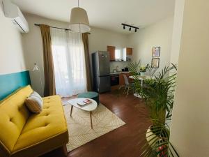 a living room with a yellow couch and a kitchen at 19 Living in Komotini