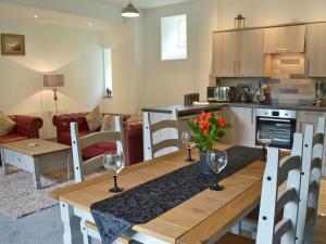 a kitchen and living room with a table with wine glasses at Rosecraddoc Manor - Stable in Saint Cleer