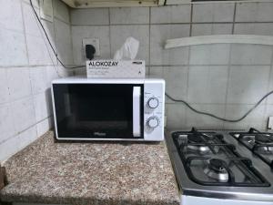 a microwave sitting on a counter next to a stove at Studio in Ajman in Ajman 