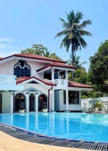 a house with a swimming pool in front of it at Yahana Beach Villa in Negombo