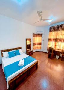 a bedroom with a large bed with blue sheets at Yahana Beach Villa in Negombo +35 photos