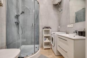 a bathroom with a shower and a washing machine at Central Platinum Apartments 8 in Rybnik +15 photos