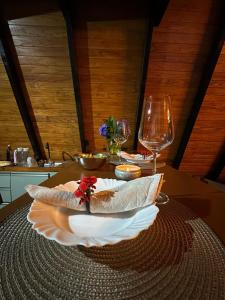 a table with a plate of food and wine glasses at Chalé Montem Verde I Refúgio na Serra Catarinense em Ponte Alta com Hidro próximo Lages, Urubici in Ponte Alta +14 photos