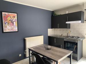 a kitchen with a wooden table in a room at studio meublé, résidence calme in Saint-Amand-les-Eaux