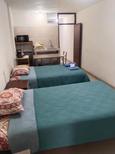 a hotel room with two beds and a sink at Centro de Tacna in Tacna