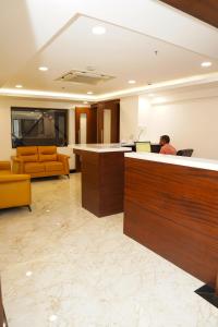 a man sitting at a desk in an office lobby at Hotel Sarovaras Legacy in Bangalore