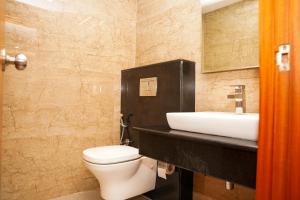 a bathroom with a white toilet and a sink at Hotel Sarovaras Legacy in Bangalore