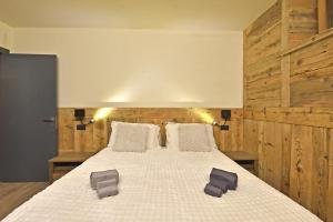 a bedroom with a large bed with wooden walls at ArtiStone - "Ancient Lodge" in Saint-Christophe +15 photos