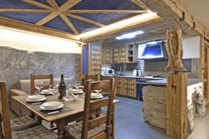 a dining room with a table and a kitchen at ArtiStone - "Ancient Lodge" in Saint-Christophe