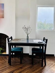 a dining room table with two chairs and a vase with flowers at Misty5 in Pattipola