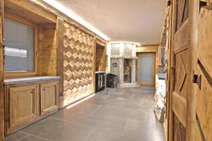 a kitchen with wooden walls and a hallway with a stove at ArtiStone - "Ancient Lodge" in Saint-Christophe