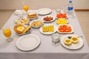 a table topped with plates and bowls of food and orange juice at Crystal Pearl Villa, Weligama - 3min to beach in Weligama