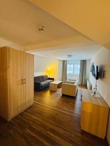 a living room with a couch and a table and a tv at Ferienhotel Alter Bahnhof garni in Prerow