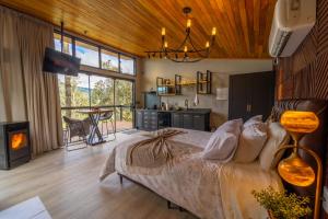a bedroom with a large bed and a fireplace at Recanto do Bici in Urubici