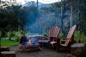 two chairs and a fire pit in a yard at Recanto do Bici in Urubici