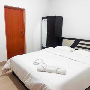 a bedroom with a large white bed with towels on it at Hotel Kiara In Shillong in Shillong +23 photos