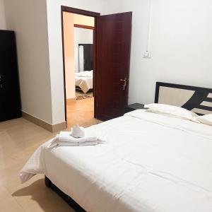 a bedroom with a large bed with white sheets at Hotel Kiara In Shillong in Shillong