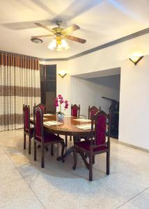 a dining room table with chairs and a ceiling fan at Yahana Beach Villa in Negombo