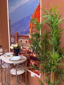 a table with two chairs and a painting of a city at Ama Esclusive Spa Firenze in Florence