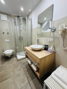 a bathroom with a sink and a shower at Ferienhotel Alter Bahnhof garni in Prerow +71 photos