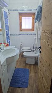 a bathroom with two sinks and a toilet and a window at Chalet La Cometa in Sauze dʼOulx +27 photos