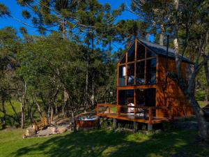 a cabin in the woods with a large window at Recanto do Bici in Urubici