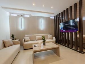 a living room with a couch and a tv at ذا سهل ستيز in Amman