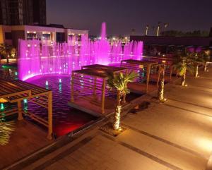 a fountain with pink lights in a city at night at Al- Abasly Suites in Baghdād