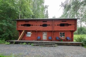 a log cabin with chairs in front of it at Getaway in the wilderness in Hämeenlinna