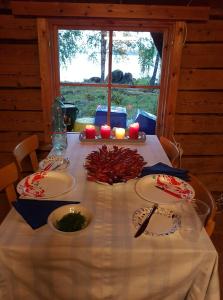 a table with a white table cloth and candles on it at Getaway in the wilderness in Hämeenlinna