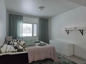 a bedroom with a bed and a window at Leinosen Lempi in Ylämylly