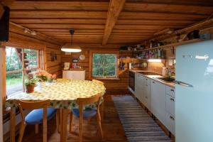 a kitchen with a table with chairs and a refrigerator at Getaway in the wilderness in Hämeenlinna