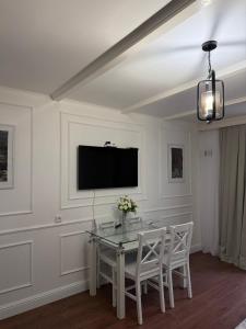 a dining room with a table and a tv on the wall at Manika Grigoleti in Grigoleti