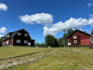 two houses and a red barn on a field at Leinosen Lempi in Ylämylly